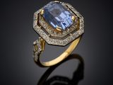 a blue sapphire and diamond ring on a black surface