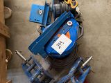 a man standing next to a clamp and a blue machine