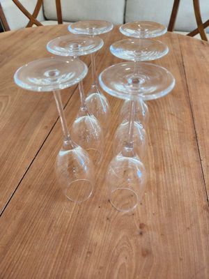 four empty wine glasses sitting on top of a wooden table