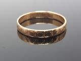 a close up of a gold ring on a reflective surface