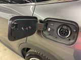 a silver car with an electric charger attached to it ' s side