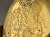 an antique brass helmet with a decorative decoration on the top of it