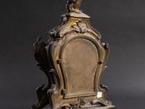 a small wooden clock with a bird on top of it