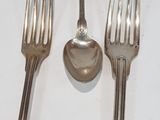 three forks and a spoon sitting on a table