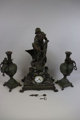 une horloge posée sur une table à côté de quelques vases