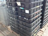 many black boxes stacked on a pallet in a warehouse