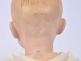 a close up of a doll ' s back with a white shirt