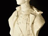 marble bust of a man in a tuxedo with a bird perched on his shoulder