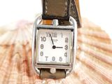 a watch sitting on top of a shell with a shell in the background