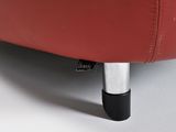 the back of a red leather couch with a black foot rest