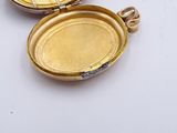 a small gold locke with a key inside of it