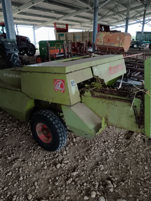 une machine verte qui est à l'arrêt dans la poussière