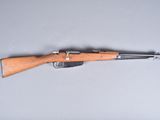 Un vieux fusil est posé sur une table, avec une cartouche à l'intérieur.