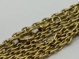 a close up of a gold chain bracelet on a white surface
