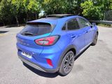 the rear end of a blue car parked in a parking lot