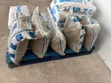 several bags of cement sitting on top of a wooden pallet