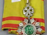 une image représentant une médaille suspendue à un ruban rouge et jaune