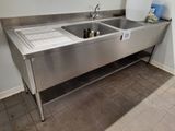 a stainless steel sink in the corner of a kitchen