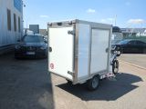 a small white box trailer parked in a parking lot