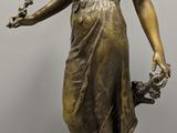 statue en bronze d'une femme tenant un oiseau sur un piédestal