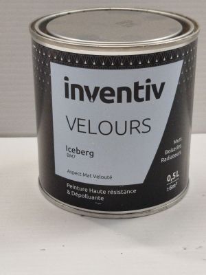 un pot de peinture posé sur une table blanche