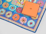an orange box sits on top of a blue and orange square scarf