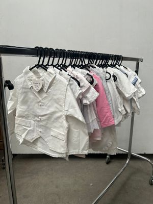 un portant sur lequel sont suspendus des vêtements, dans une pièce