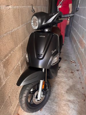 un scooter garé à côté d'un mur de briques