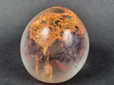 a glass ball with a design on it on a black surface