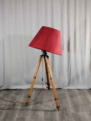 une lampe posée sur un trépied et munie d'un abat-jour rouge
