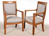 deux chaises en bois avec des accoudoirs rembourrés
