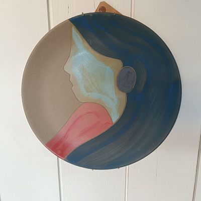 une assiette sur laquelle est peinte une femme