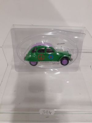 a small green toy car in a clear display case