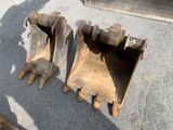 two large excavators sitting on the ground next to each other