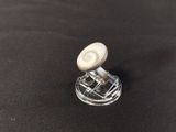 a close up of a small glass object with a button on it