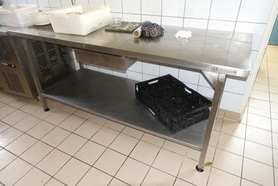 une table en métal sur laquelle est posé un panier, dans une cuisine