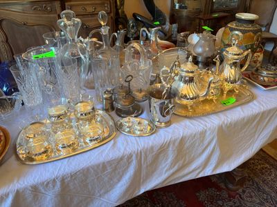 une table sur laquelle sont disposés de nombreux objets en argent et en verre