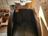 un fauteuil en cuir noir dans un coin d'une salle de bains