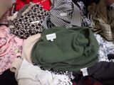 a pile of clothes sitting on top of a black suitcase