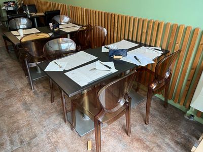 des tables et des chaises dans un restaurant, couvertes de papiers et encore de papiers