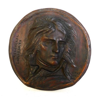 a bronze plaque of a man with a pipe in his mouth