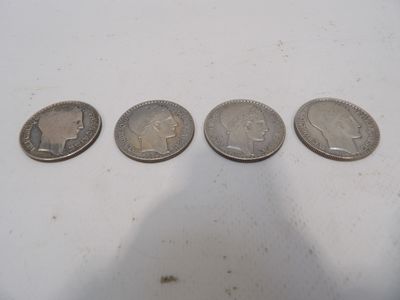 quatre types de pièces différents posés sur une surface blanche