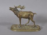 statue en bronze représentant un cerf aux bois imposants, posée sur un socle