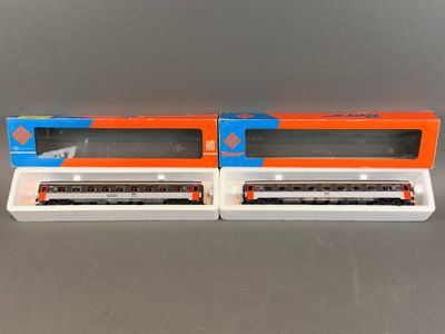 deux petits trains miniatures posés l'un à côté de l'autre sur une table