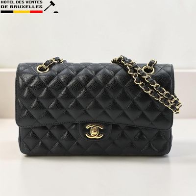 un sac Chanel noir posé sur une table blanche