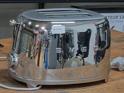 a toaster sitting on a table with a cord attached to it