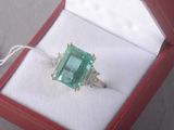 a ring in a red box with a green stone in it