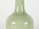 a green vase that has a design on it