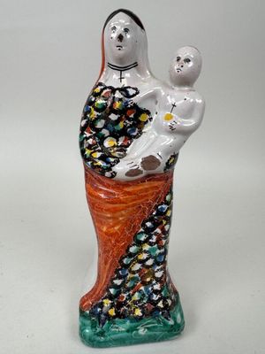 une image représentant une figurine en céramique d'une femme tenant un bébé dans ses bras