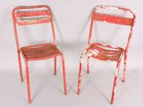 two red chairs sitting next to each other on a white surface
